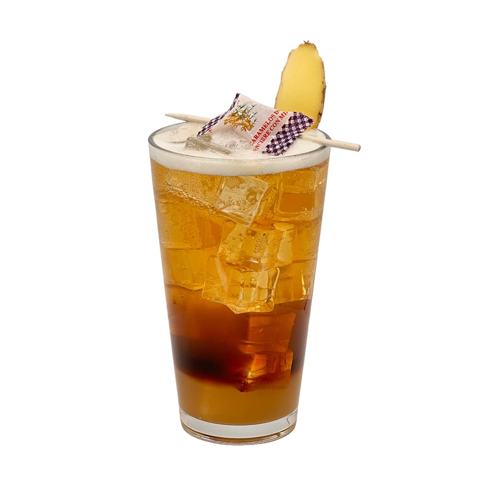 Atmosphere 0.0 Pilsner ginger cocktail with ginger candy and ginger slice garnishes in a tall glass on a white background.